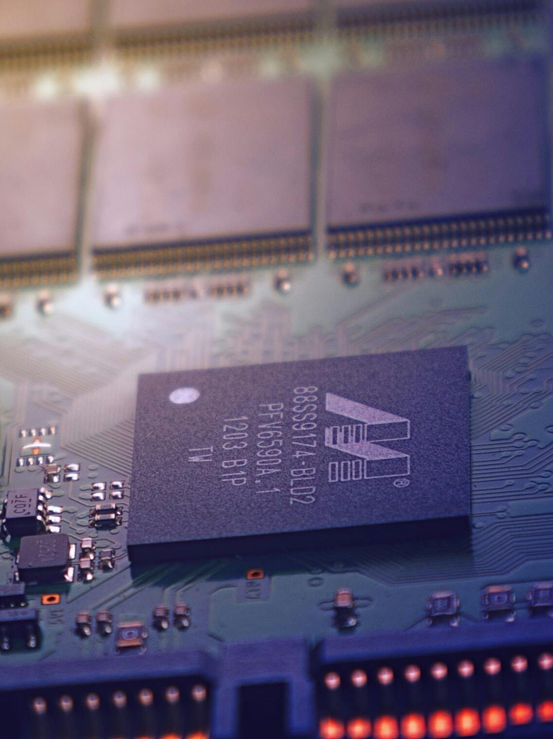 Detailed image of an electronic circuit board showing microchips and intricate wiring in a modern technological setting.