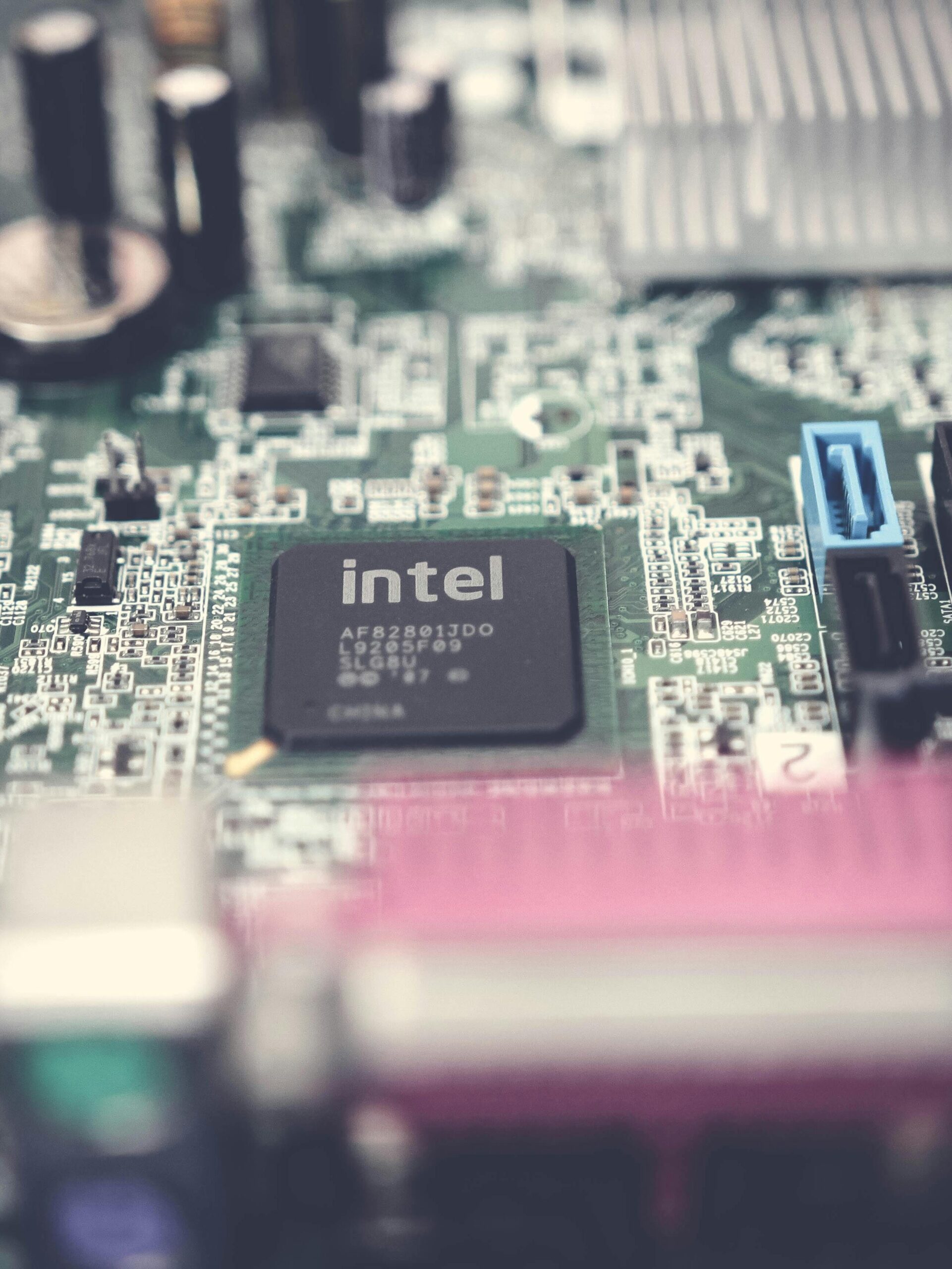 Detailed image of a computer motherboard highlighting an Intel chip with surrounding components.